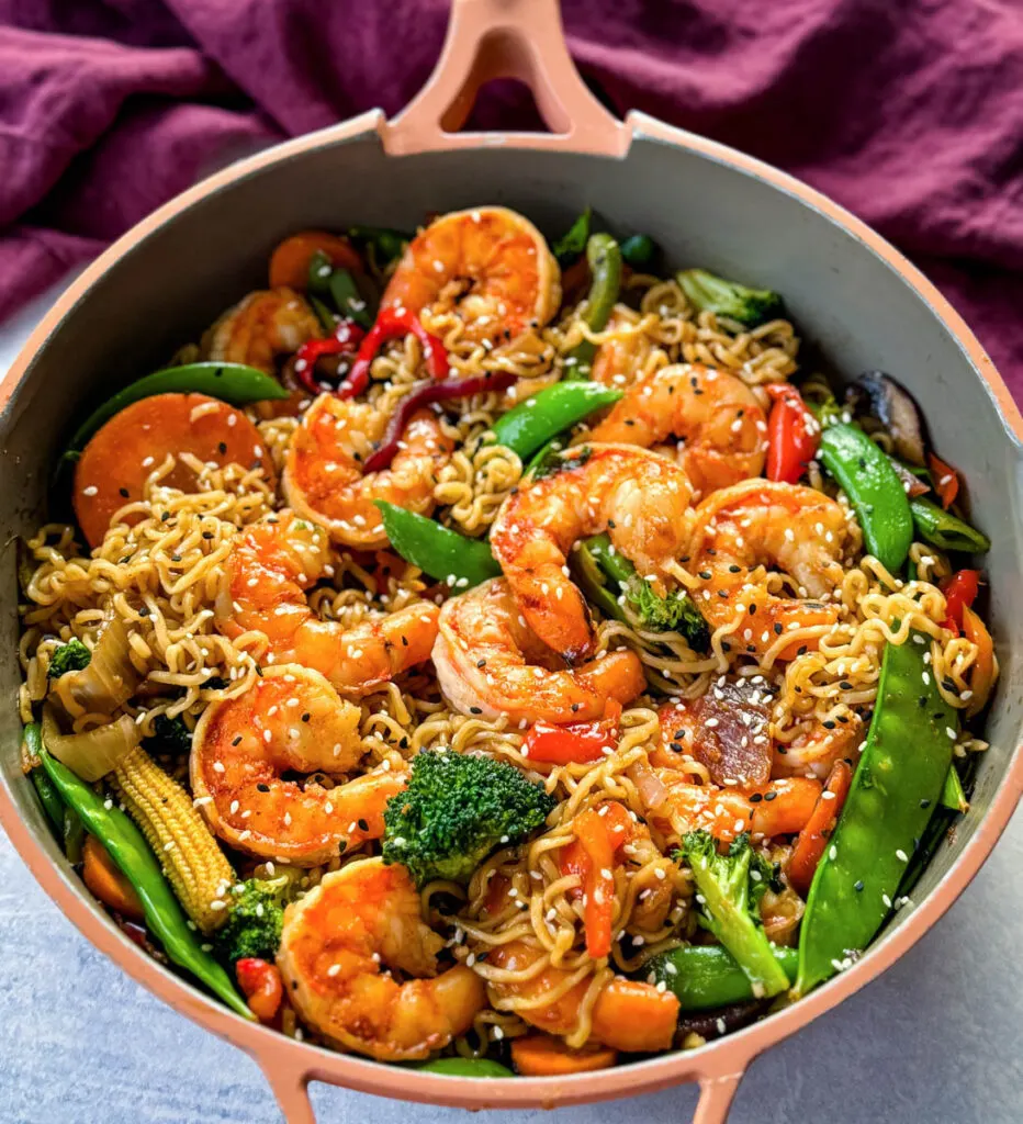 shrimp stir fry with noodles, vegetables, and a homemade sauce in a skillet