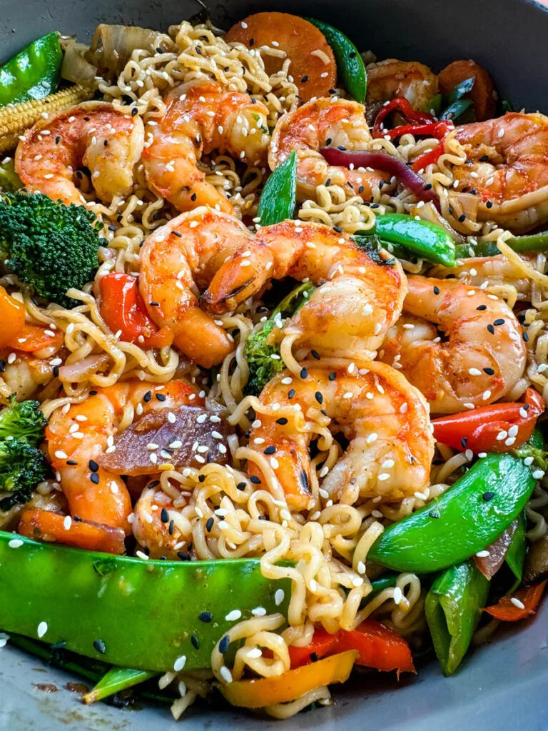 shrimp stir fry with noodles, vegetables, and a homemade sauce in a skillet