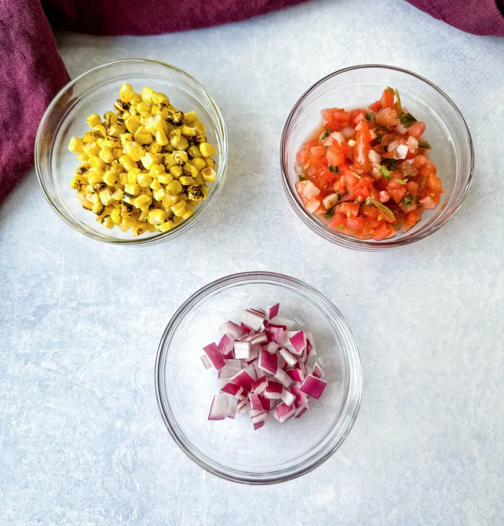 roasted corn, salsa, and chopped onions in separate glass bowls