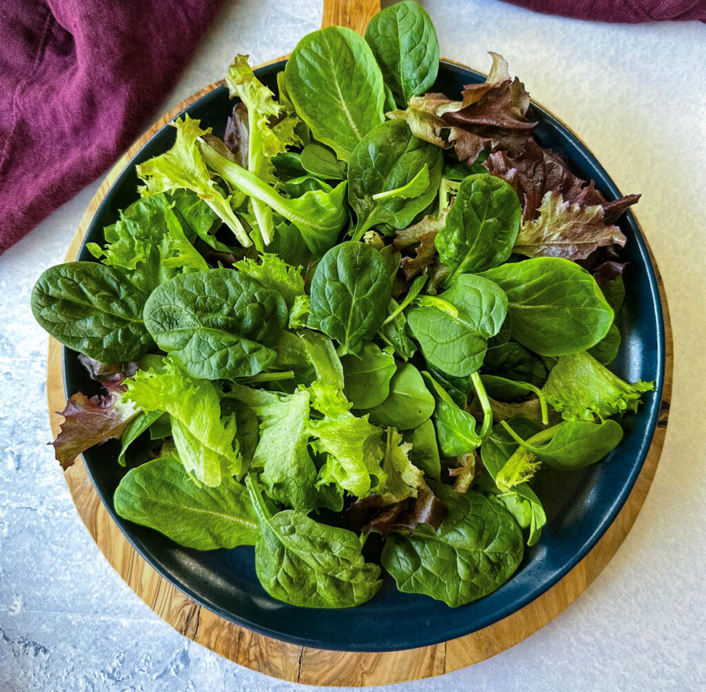 fresh salad greens on a blue plate