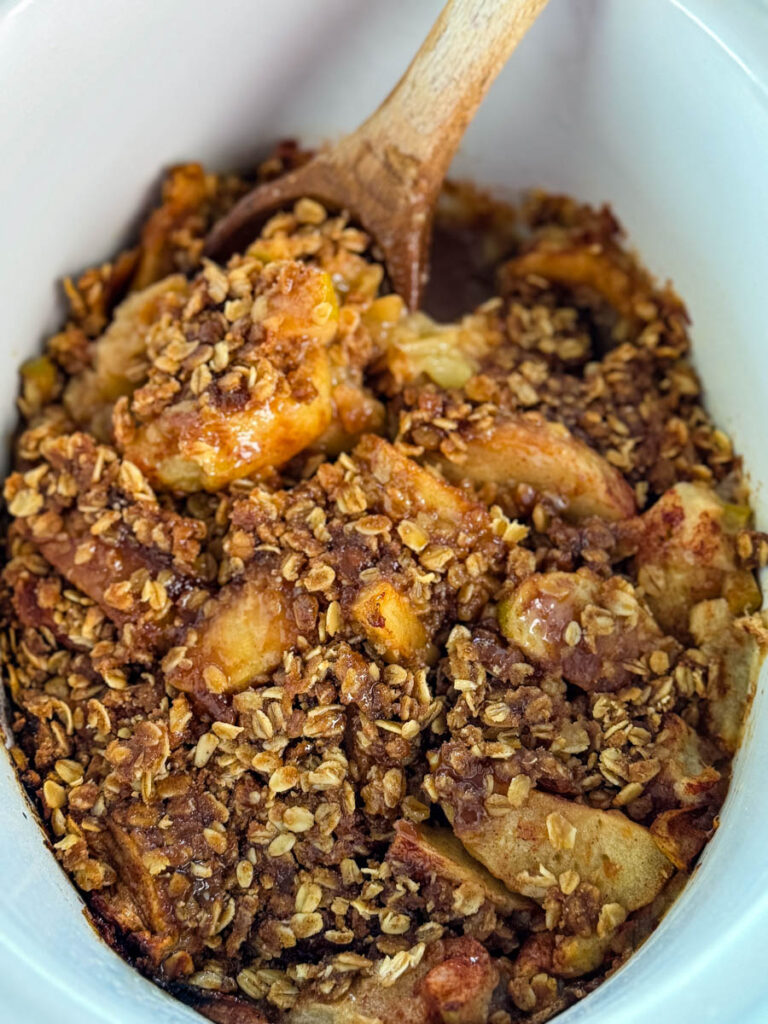 apple crisp in a white Crockpot slow cooker