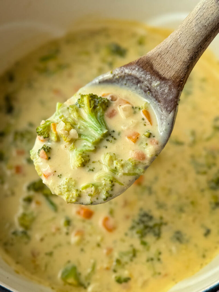 a wooden spoon full of broccoli cheddar soup