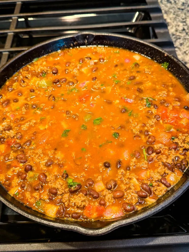 uncooked Mexican beef and rice in a cast iron skillet