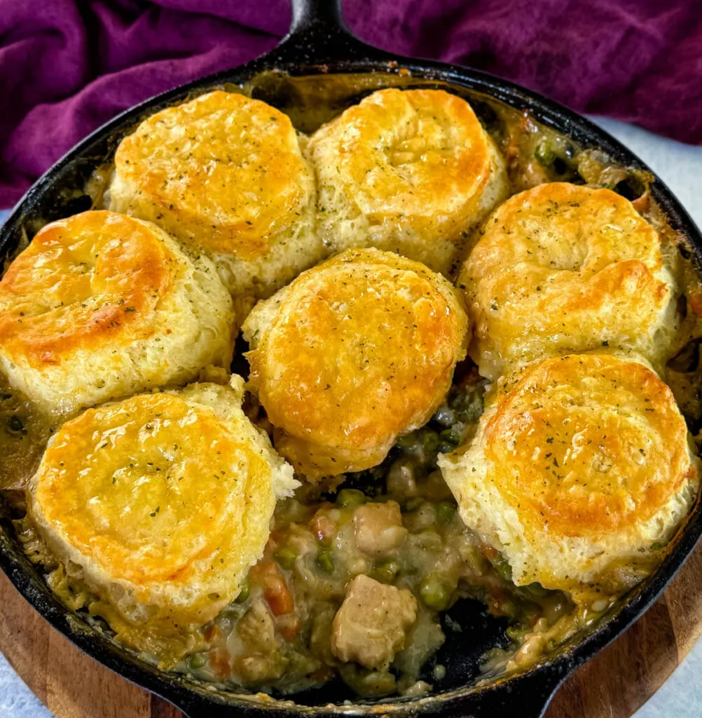 chicken pot pie with biscuits in a cast iron skillet