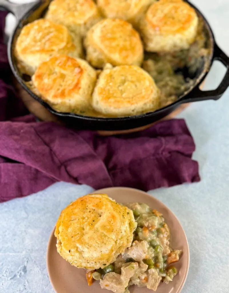 chicken pot pie with biscuits in a cast iron skillet and on a plate