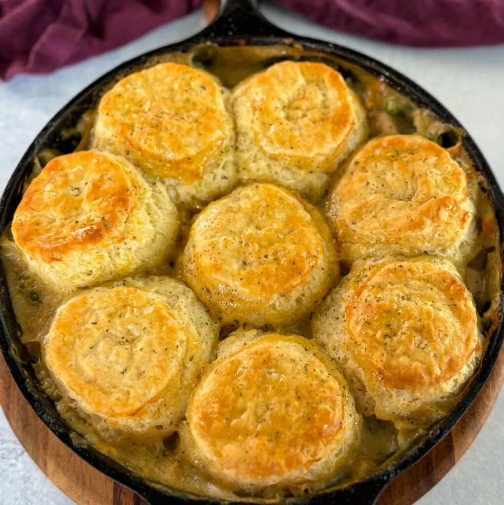 chicken pot pie with biscuits in a cast iron skillet