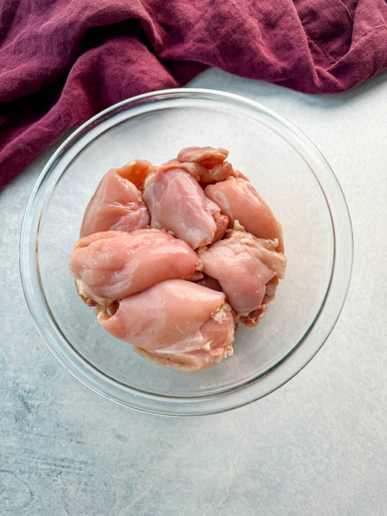 raw skinless, boneless chicken thighs in a glass bowl