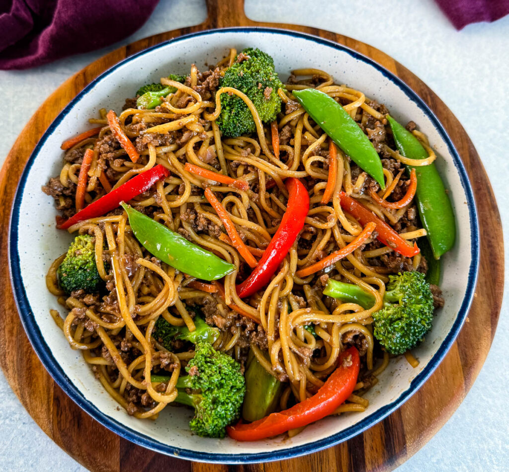 ground beef lo mein and vegetables in a white bowl