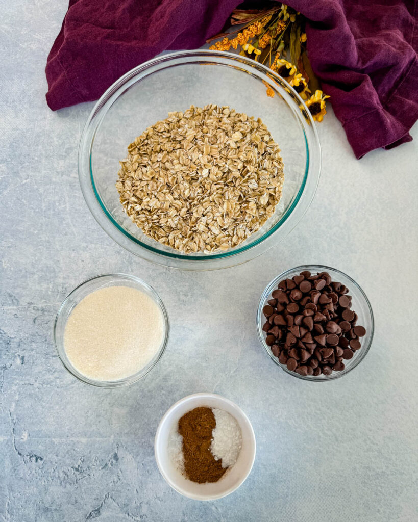 rolled oats, sweetener, chocolate chips, and pumpkin pie spice in separate bowls