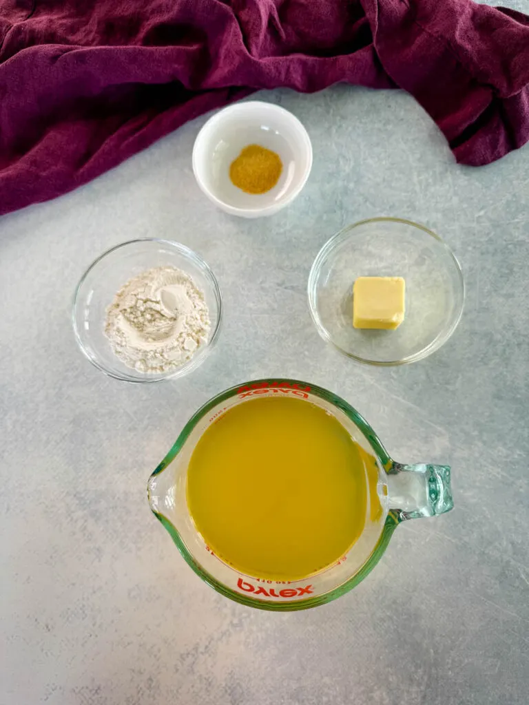 spices, flour, butter, and broth in separate glass bowls