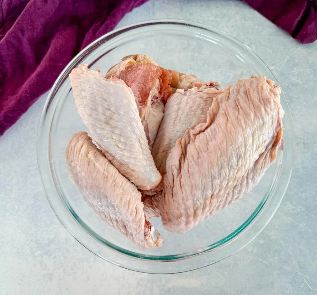 raw turkey wings in a glass bowl