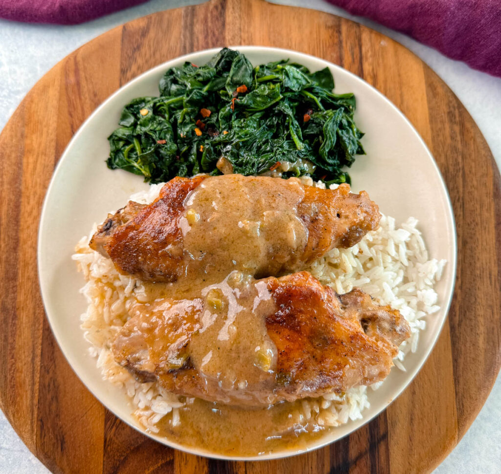 smothered turkey wings and gravy on a plate with spinach