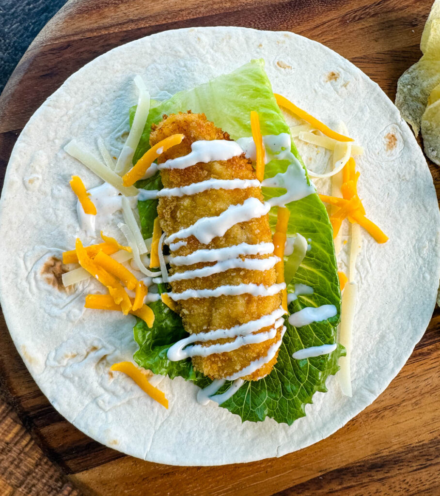 chicken snack wrap on a tortilla with ranch dressing and shredded cheese