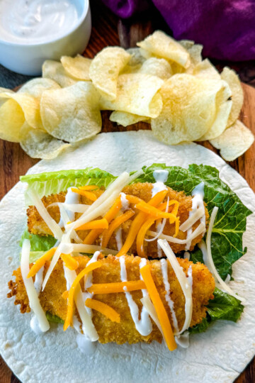 chicken snack wrap on a tortilla with ranch dressing and shredded cheese with chips