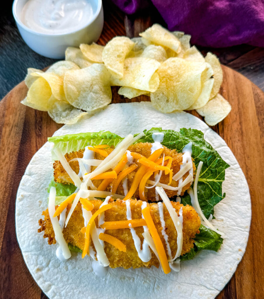 chicken snack wrap on a tortilla with ranch dressing and shredded cheese with chips