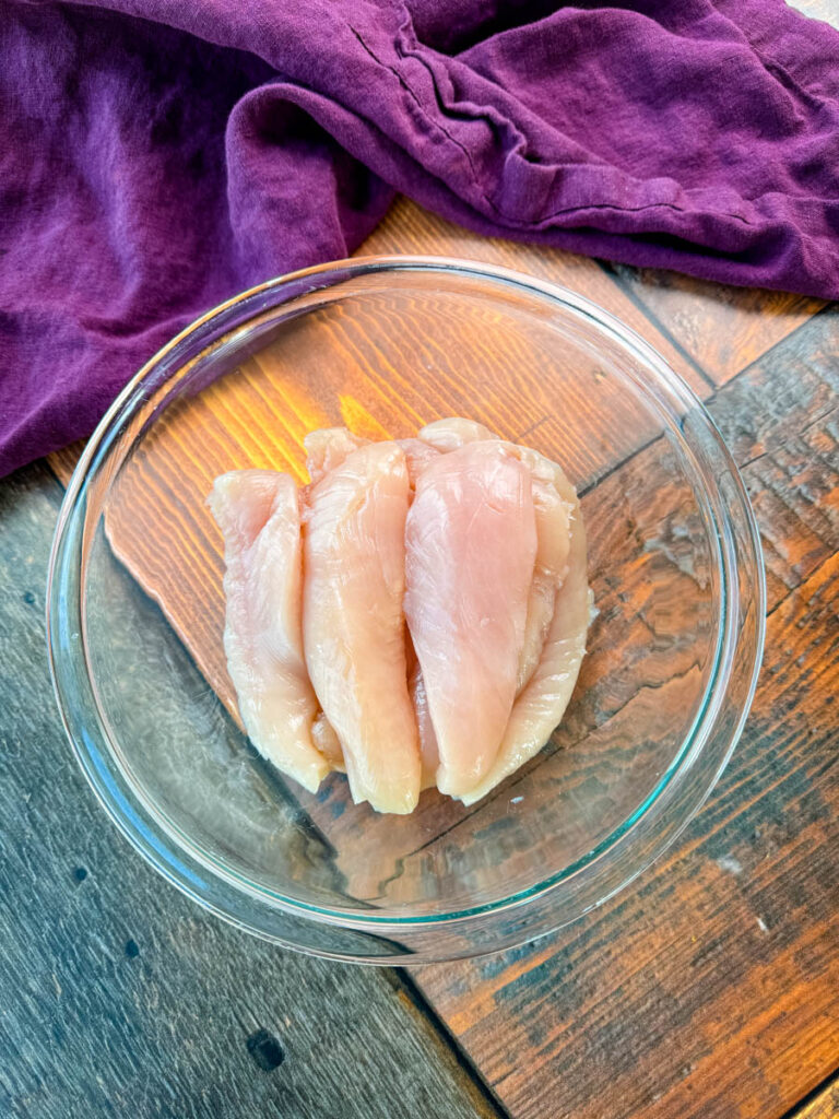 raw chicken tenderloins in a glass bowl