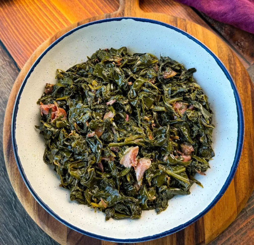 collard greens and ham hocks in a white bowl