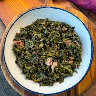 collard greens and ham hocks in a white bowl