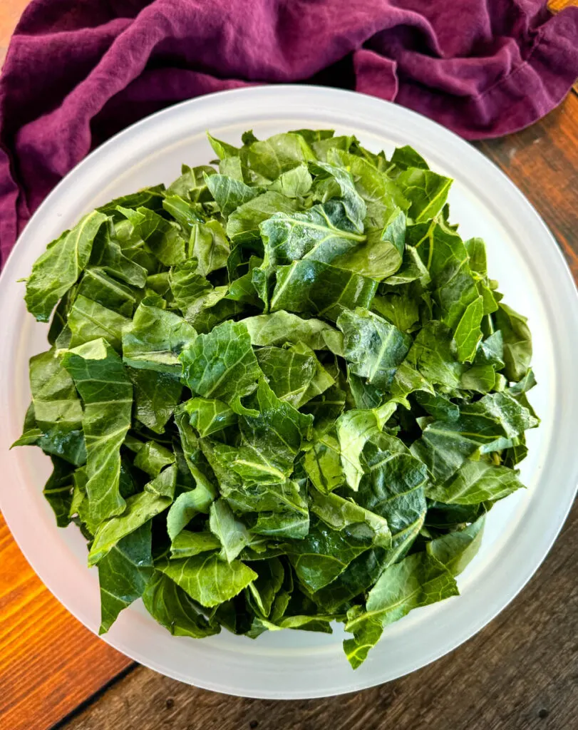 fresh, picked, and washed collard greens in a white bowl