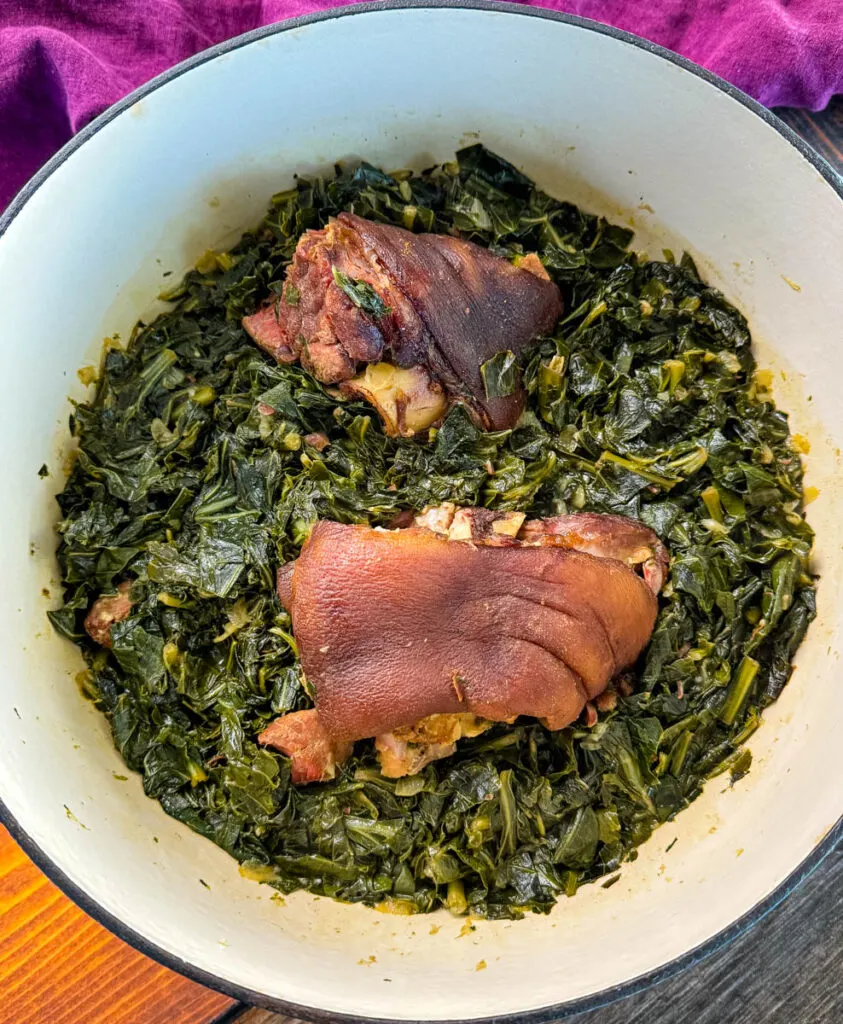 collard greens and ham hocks in a Dutch oven