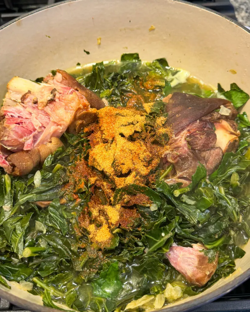 collard greens, spices, and ham hocks in a Dutch oven