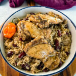 jerk chicken, rice, peas, red beans, and peppers in a white bowl