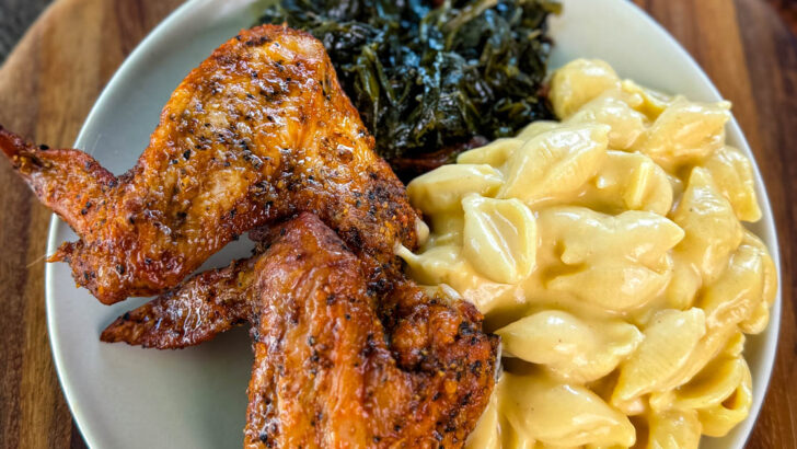 fried chicken wings, collard greens, and stovetop mac and cheese on a plate