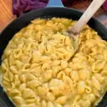 stovetop mac and cheese in a cast iron skillet with a wooden spoon