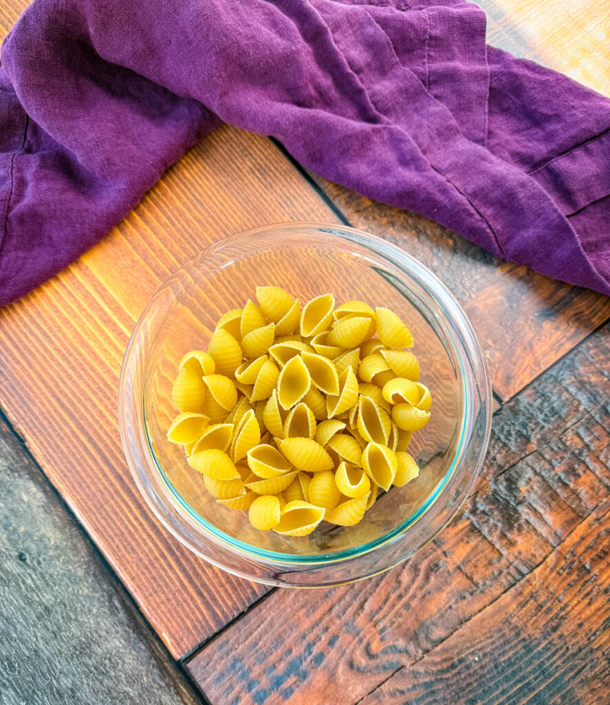 uncooked shells pasta in a glass bowl