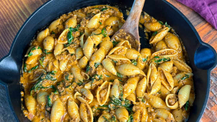 high protein beef and shells pasta with spinach in a cast iron skillet