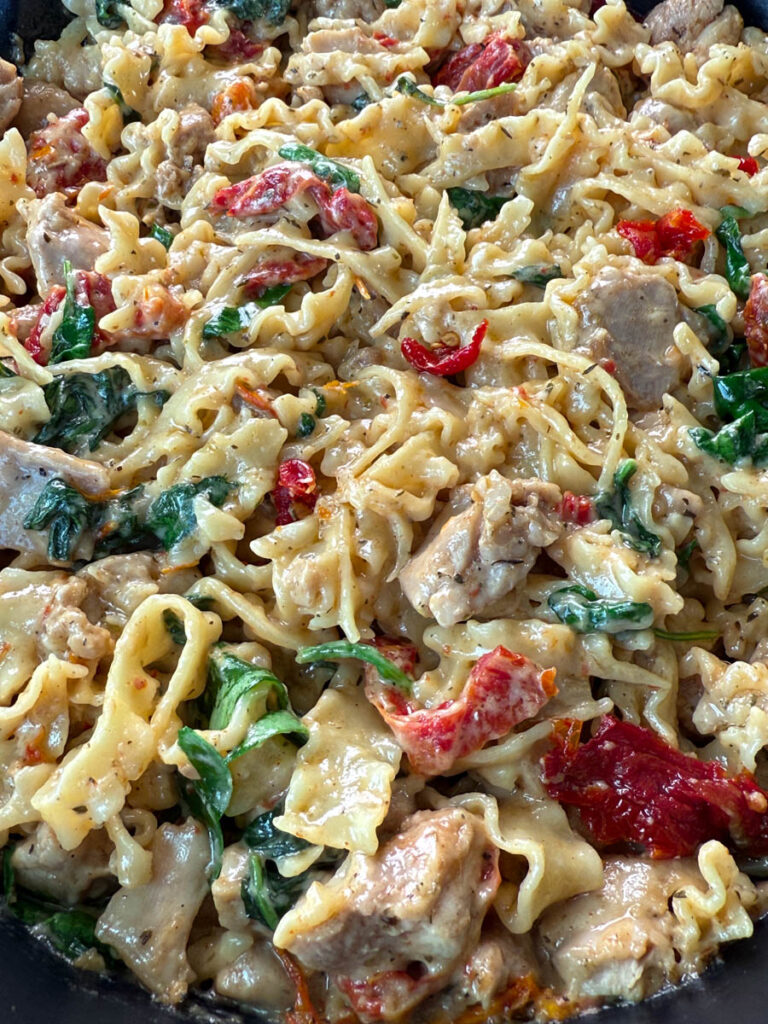 pot full of marry me chicken pasta with sundried tomatoes, parmesan, and spinach