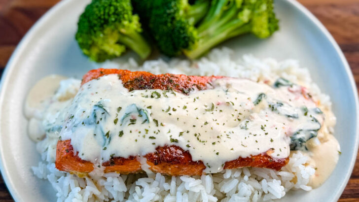 Tuscan style marry me salmon with cream sauce with rice and broccoli on a plate