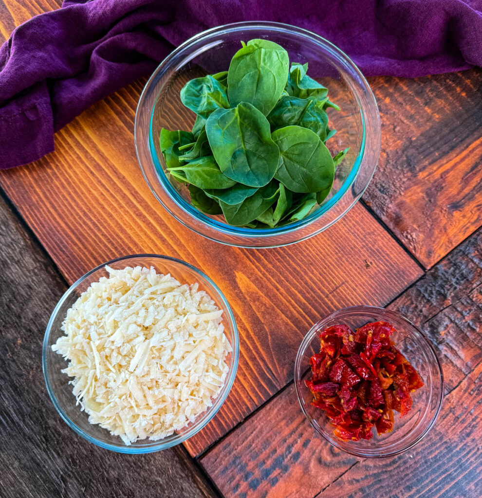 spinach, Parmesan reggiano cheese, and sundried tomatoes in separate bowls