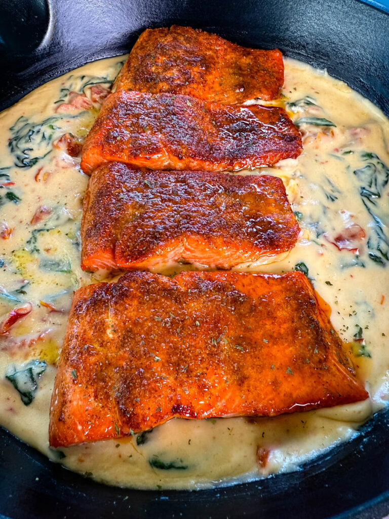 Tuscan style marry me salmon with cream sauce in a skillet