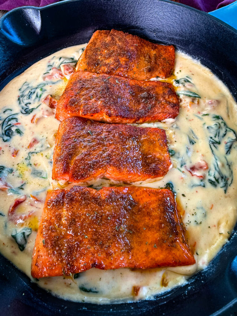 Tuscan style marry me salmon with cream sauce in a skillet