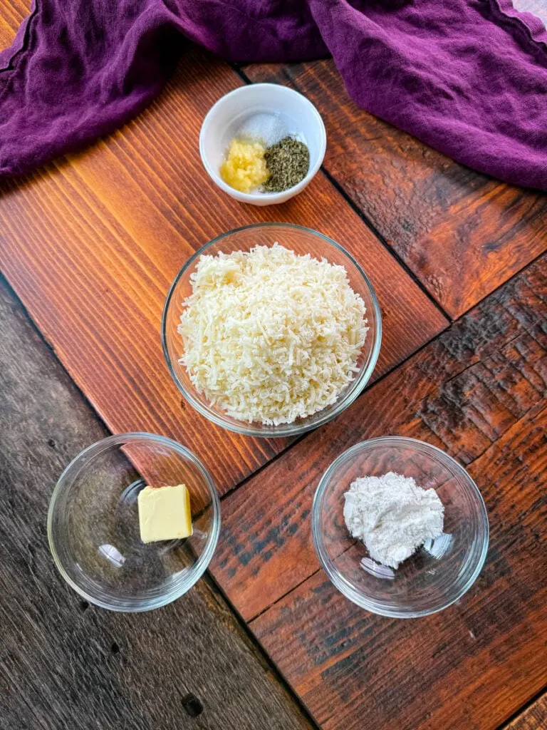 grated Parmesan reggiano cheese, spices, butter, and flour in separate glass bowls