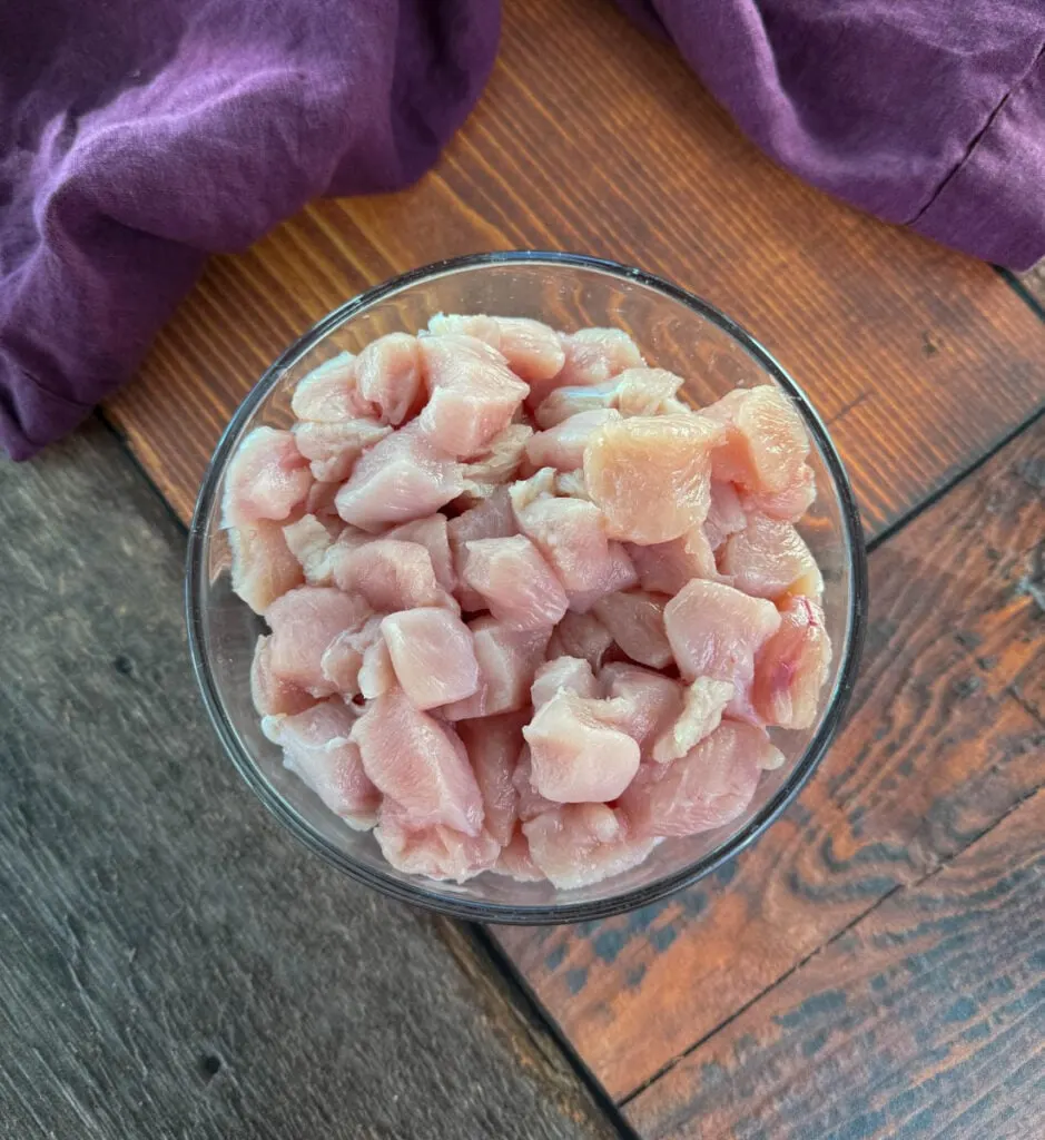 raw diced chicken breast in a glass bowl