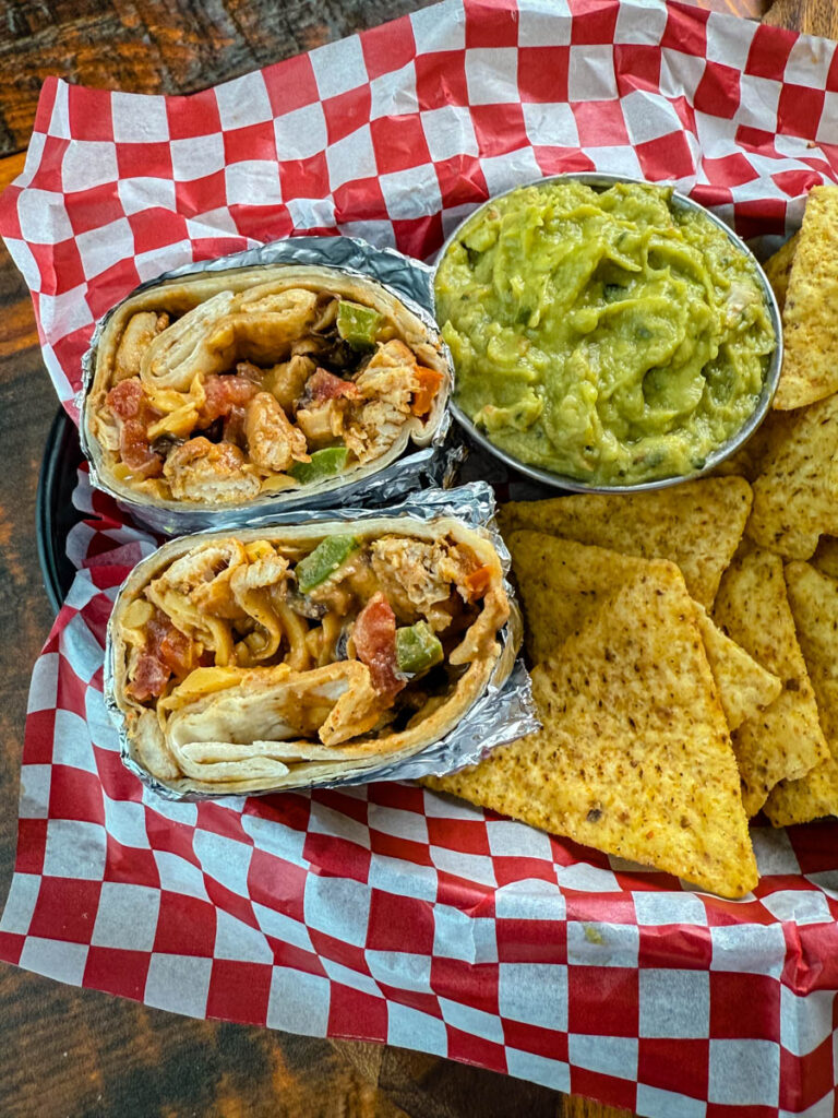 high protein chicken burritos, guacamole, and chips in a bowl