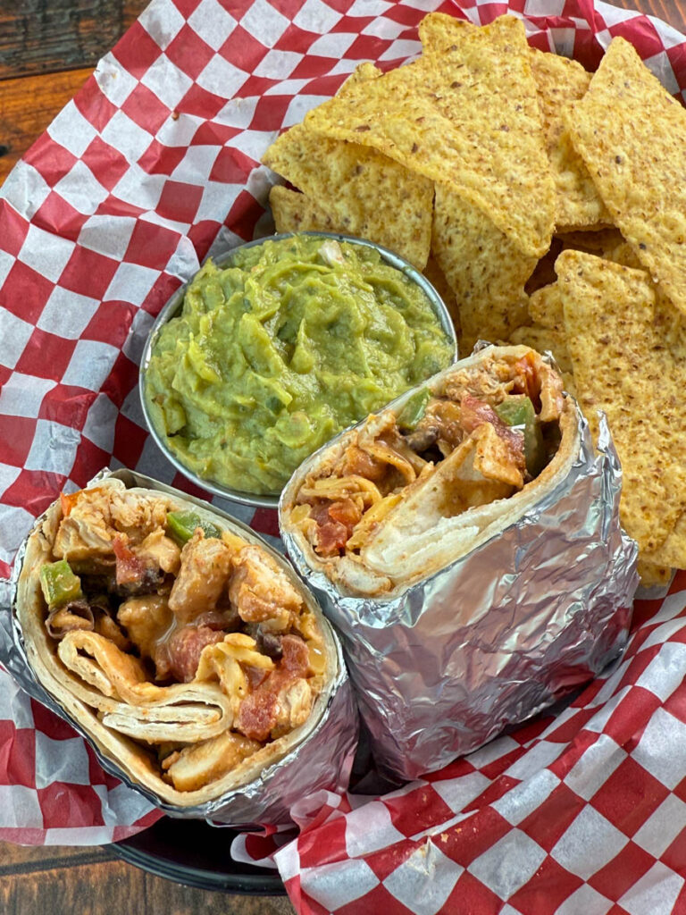 high protein chicken burritos, guacamole, and chips in a bowl