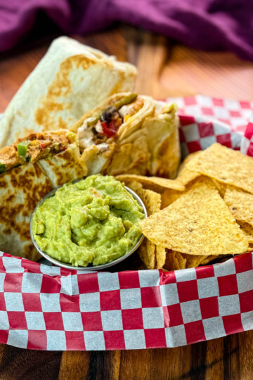 high protein chicken burritos, guacamole, and chips in a bowl