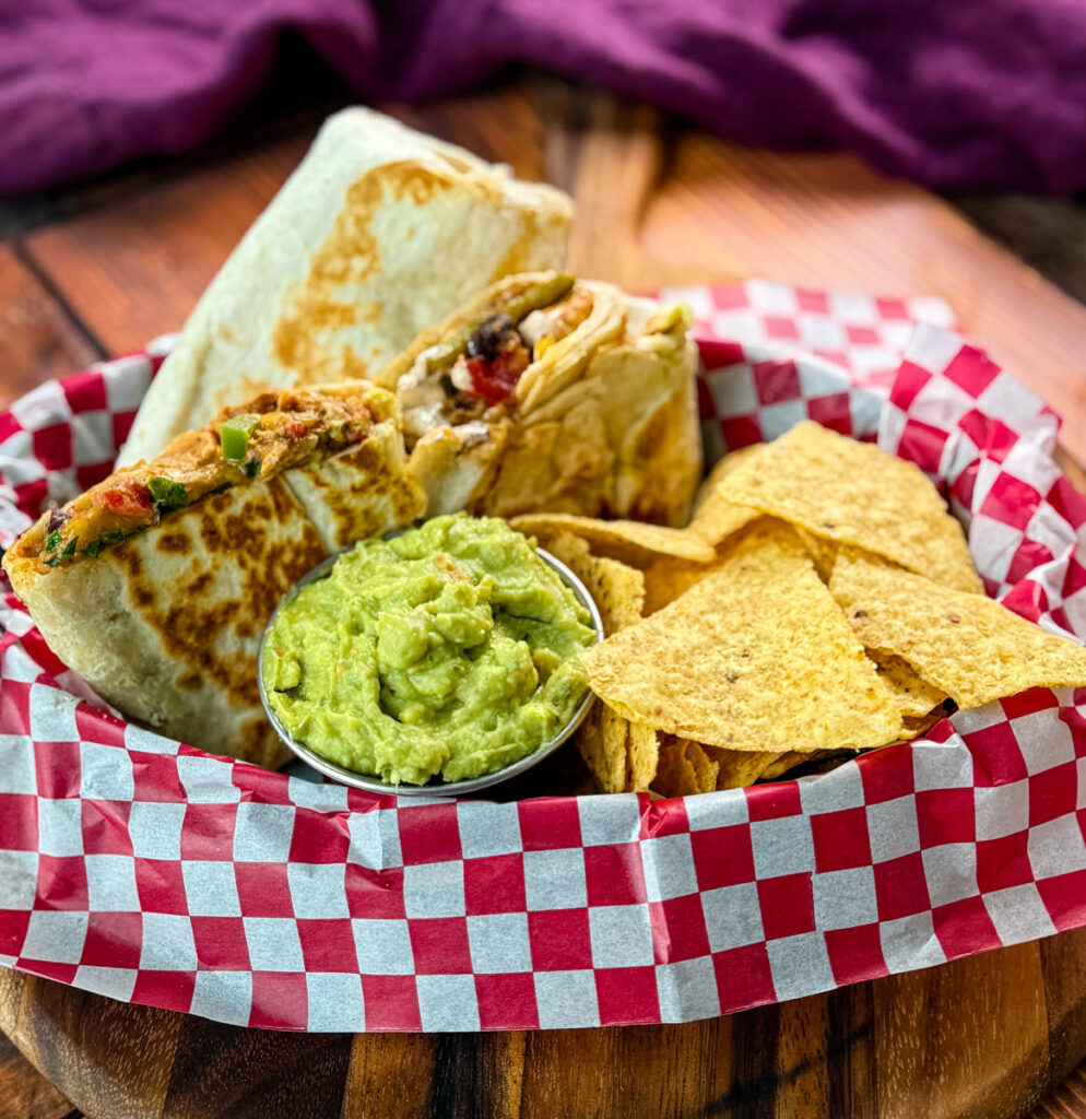 high protein chicken burritos, guacamole, and chips in a bowl