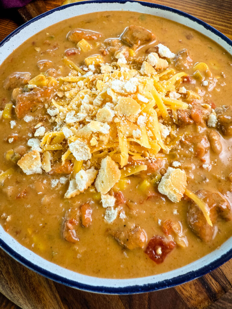 high protein chicken chili in a white bowl with crackers and a spoon