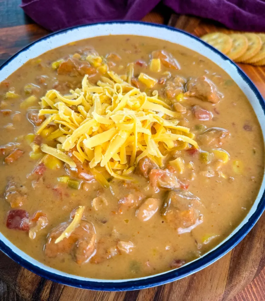 high protein chicken chili in a white bowl with grated cheese