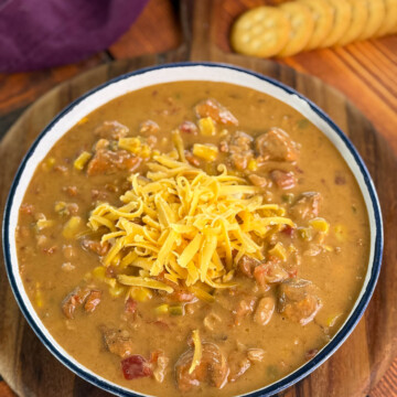 high protein chicken chili in a white bowl with grated cheese