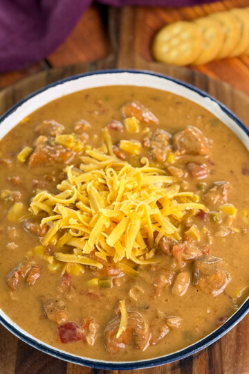 high protein chicken chili in a white bowl with grated cheese