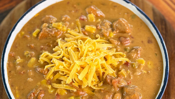 high protein chicken chili in a white bowl with grated cheese