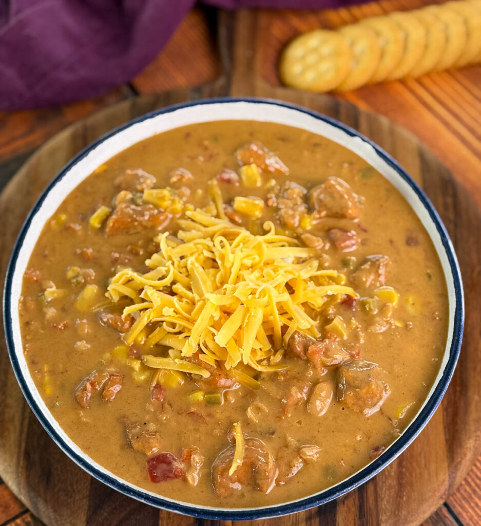 high protein chicken chili in a white bowl with grated cheese