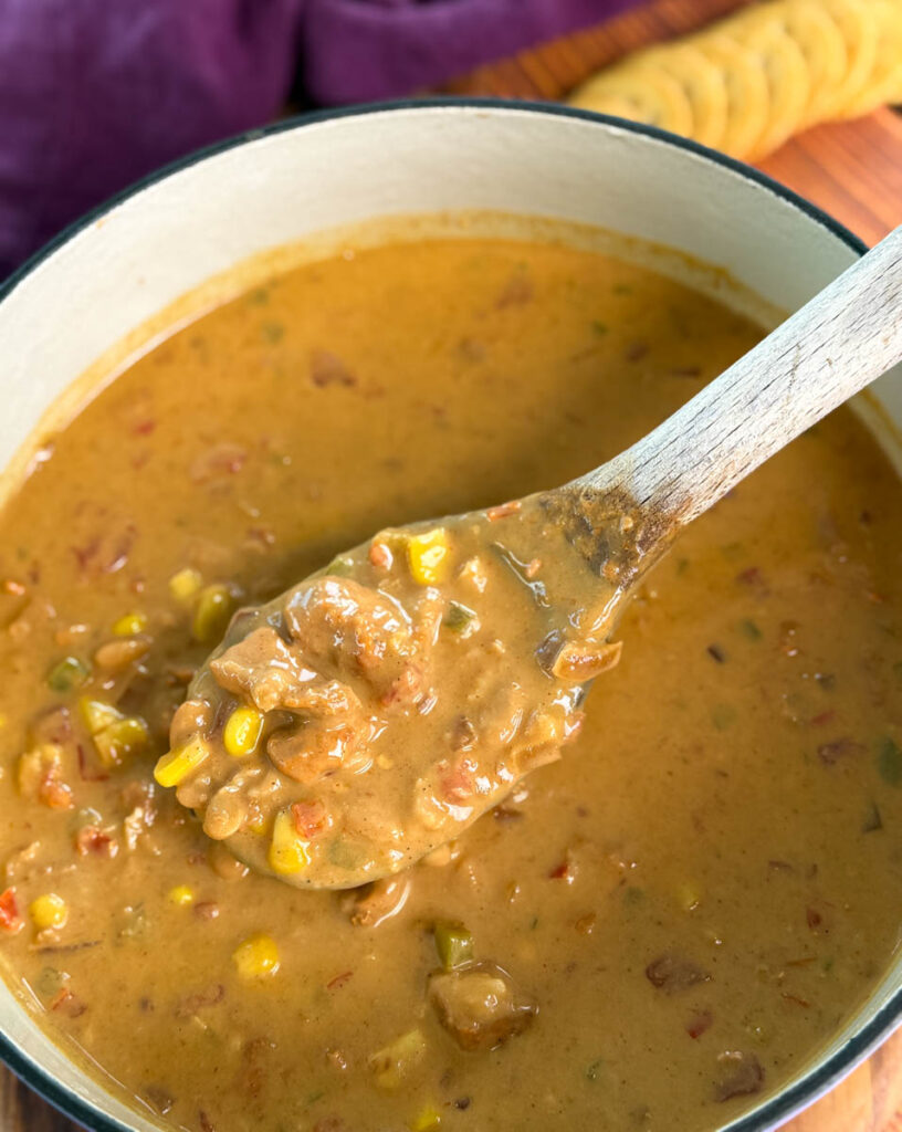 high protein chicken chili in a pot with a wooden spoon